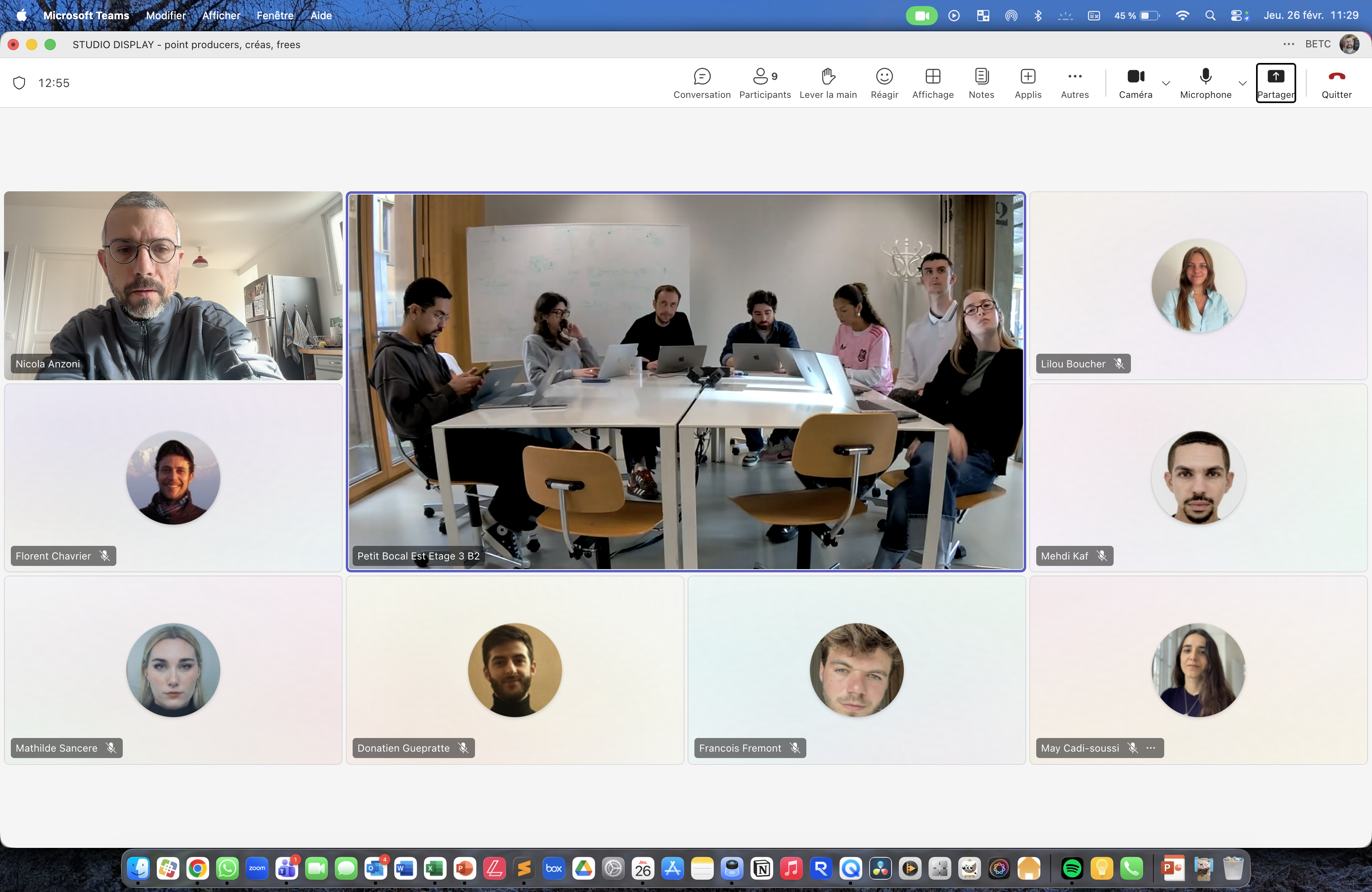 Capture d’écran Microsoft Teams d’une réunion en salle avec plusieurs personnes autour d’une table et participants distants affichés à l’écran.