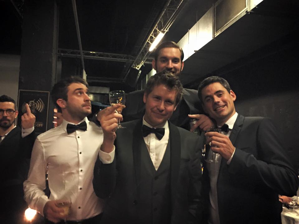 4 personnes en costard, avec du champagne.