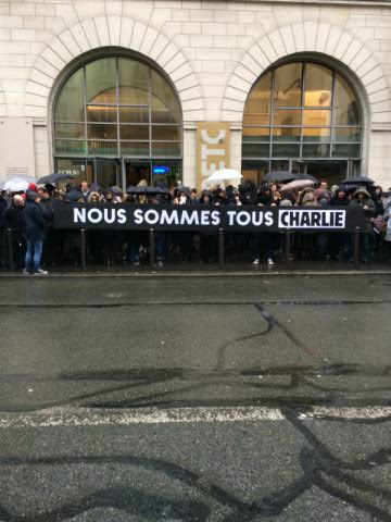 Toute l'agence devant l'entrée, avec le message nous sommes tous Charlie