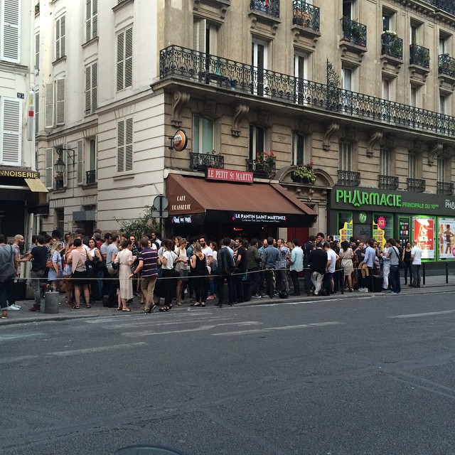 Une foule dans un bar, vue de loin.